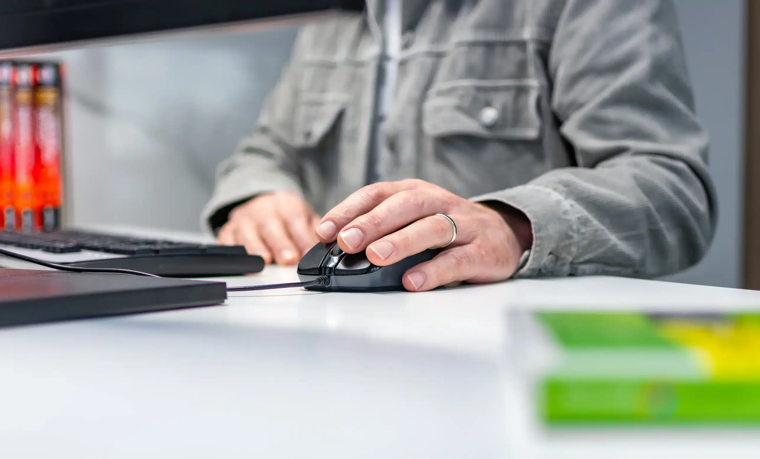 Persoon achter computer bedient de muis.